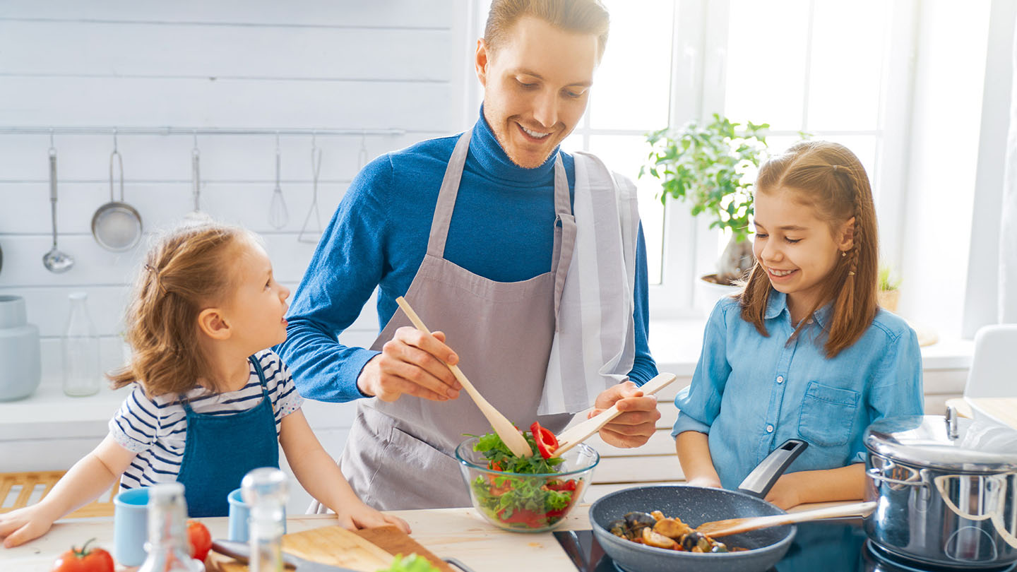 Porodica priprema zdrav obrok u kuhinji.