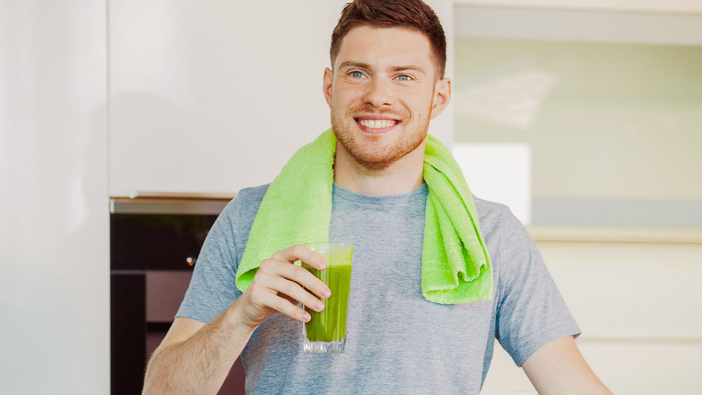 Čovek uživa u zdravom zelenom smutiju.