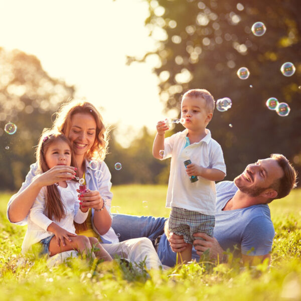 Bezbrižna, zdrava porodica koja se igra napolju.