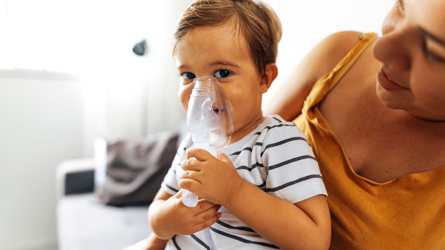 Dete sa maskom za disanje i njegova majka.