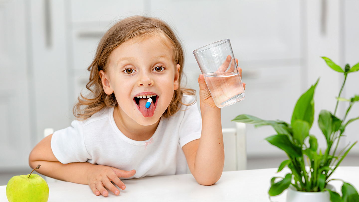 Mlada učenica uzima dodatak ishrani kako bi poboljšala imunitet.