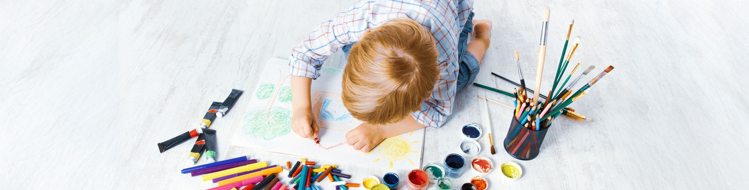 Dete se igra bojicama na podu.