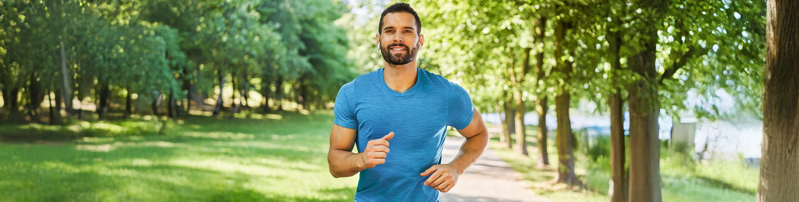 Čovek trči u parku, fizička aktivnost.