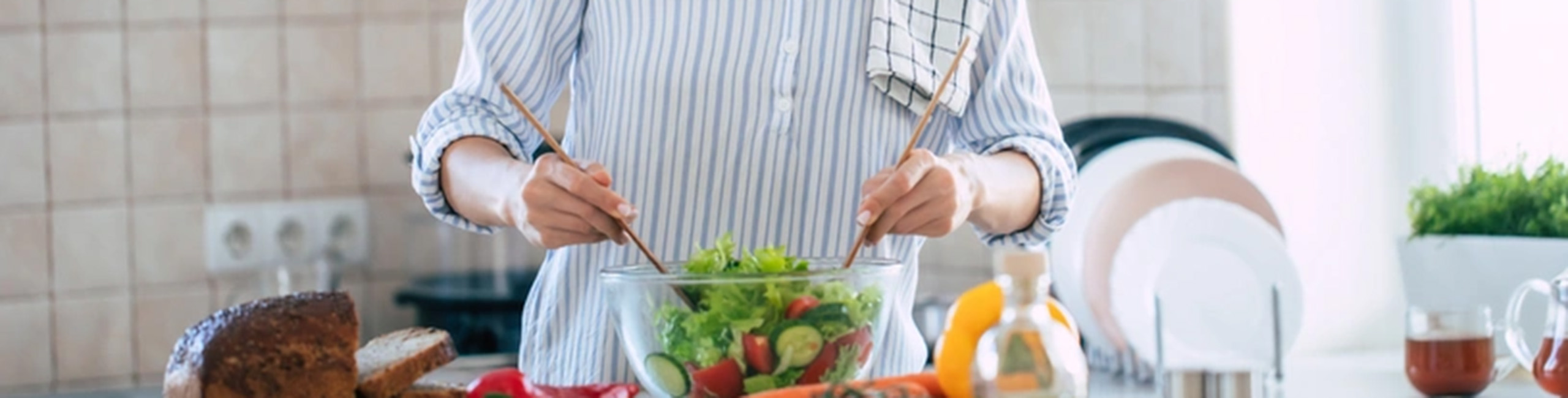 Žena priprema zdravu salatu punu vitamina C i cinka.